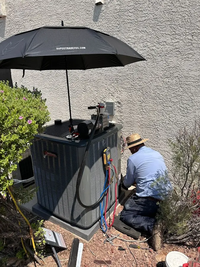 HVAC technician performing outdoor AC maintenance in East Point